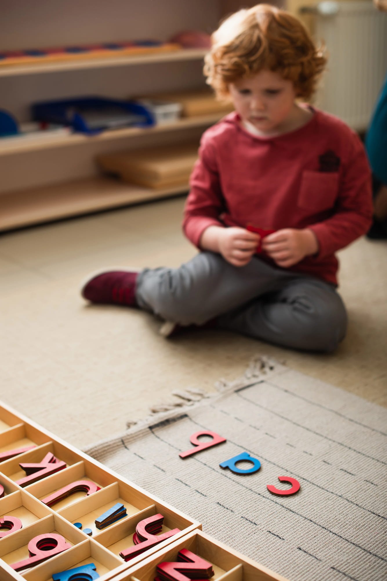 Child playing with letter blocks spelling the word cab