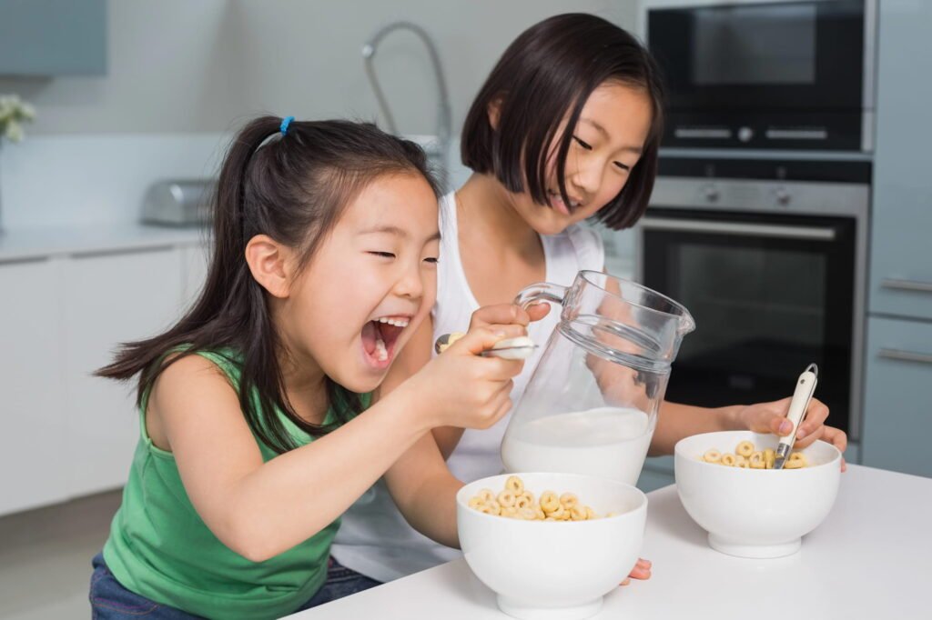 Two girls eating breakfast cereal
